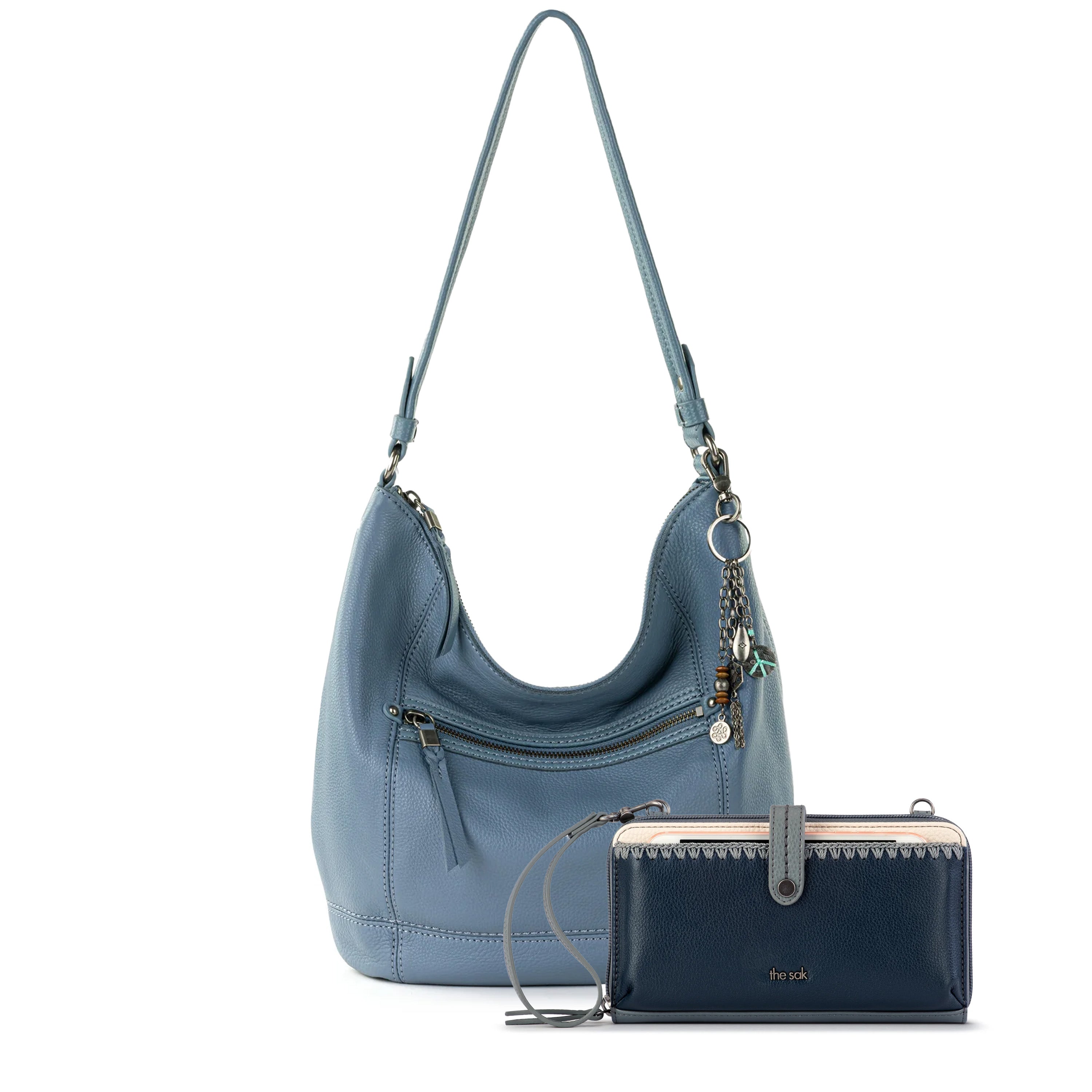 Blue leather hobo bag with shoulder straps and matching dark navy smartphone wallet with wrist strap.